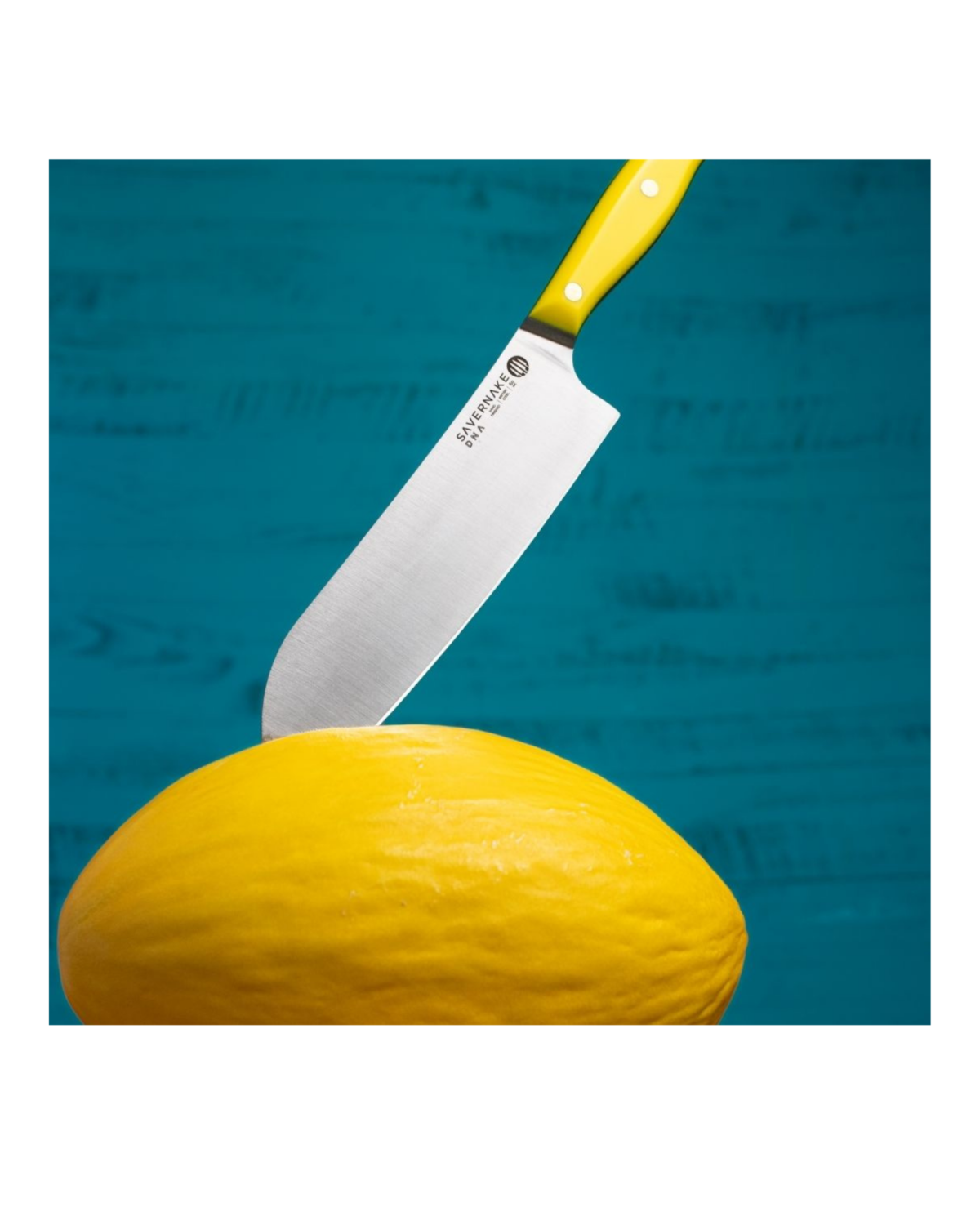 Yellow-handled knife cutting into a whole honeydew melon against a turquoise background