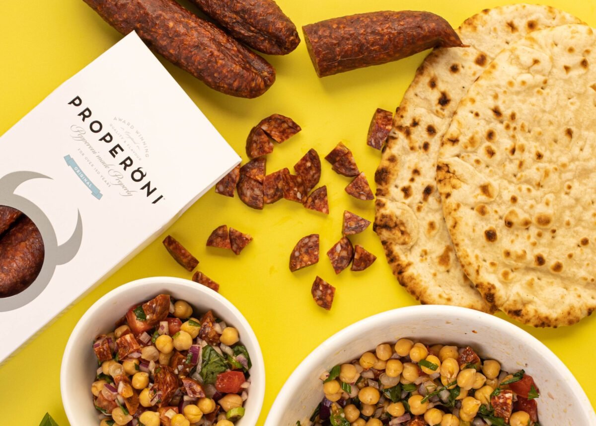 Properoni pepperoni with flatbread and two bowls of chickpea salad, shot overhead on yellow