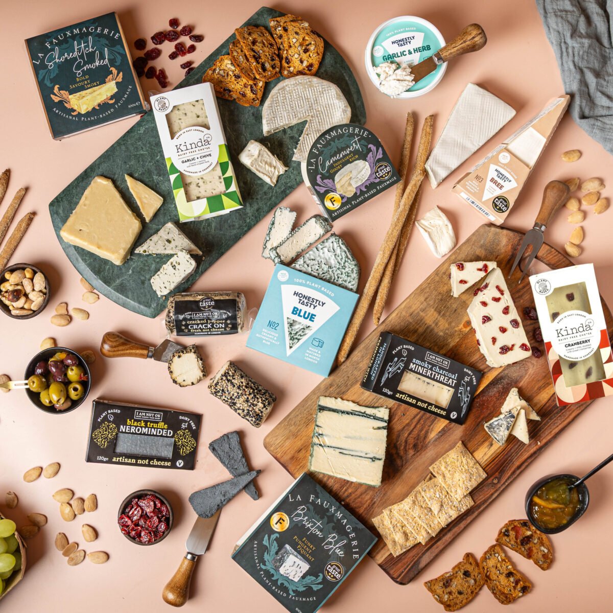 Overhead plant-based cheese board with crackers, olives, nuts and dried cranberries