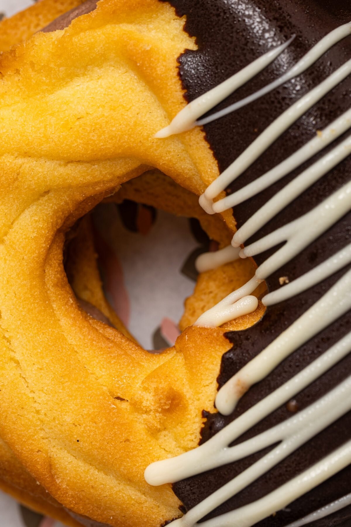 Half-dipped chocolate doughnut finished with a white chocolate drizzle, shot close