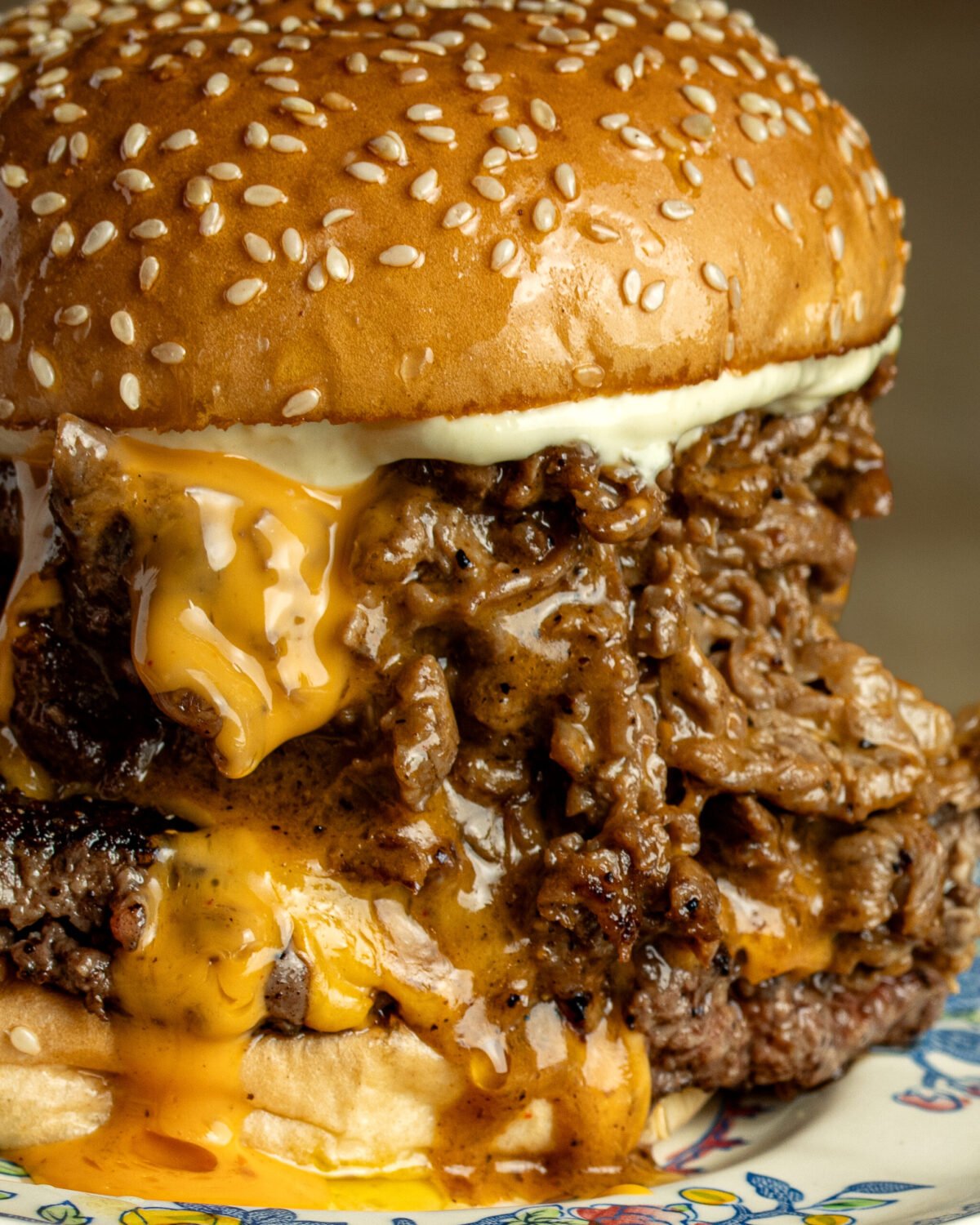 Close-up of a Red Dog Saloon cheesesteak burger, shredded steak under melted cheese