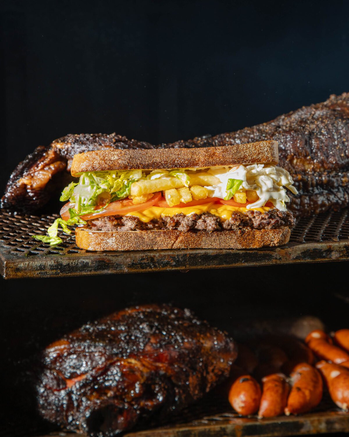 Red Dog Saloon burger in toasted bread with fries and slaw, resting on a smoker shelf