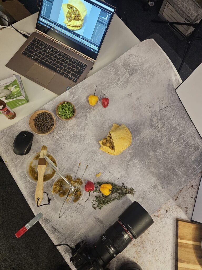 Overhead of the on-site studio: backdrop, tethered laptop, scotch bonnets, thyme and pimento
