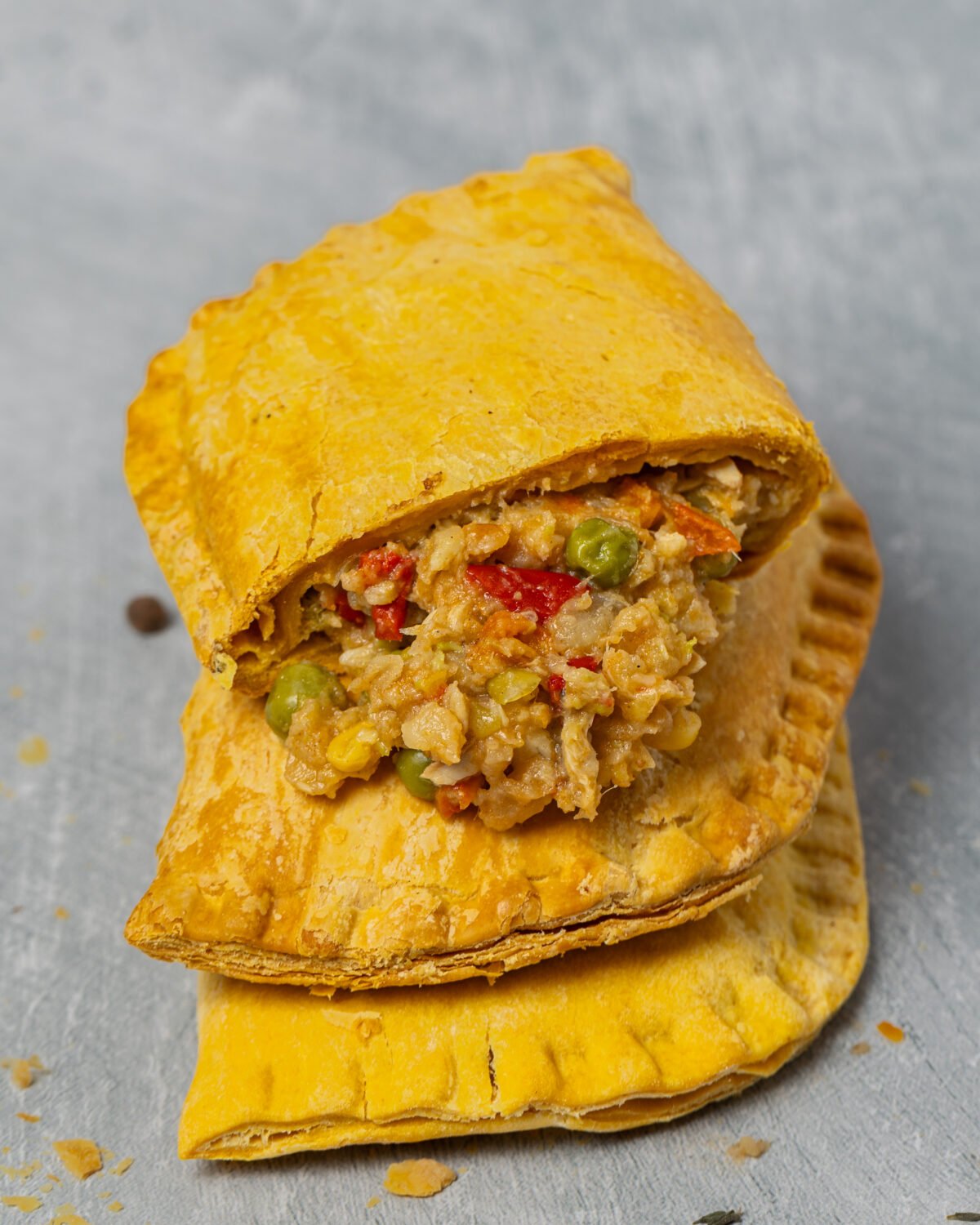 Golden Jamaican patty broken open showing the filling and flaky pastry layers