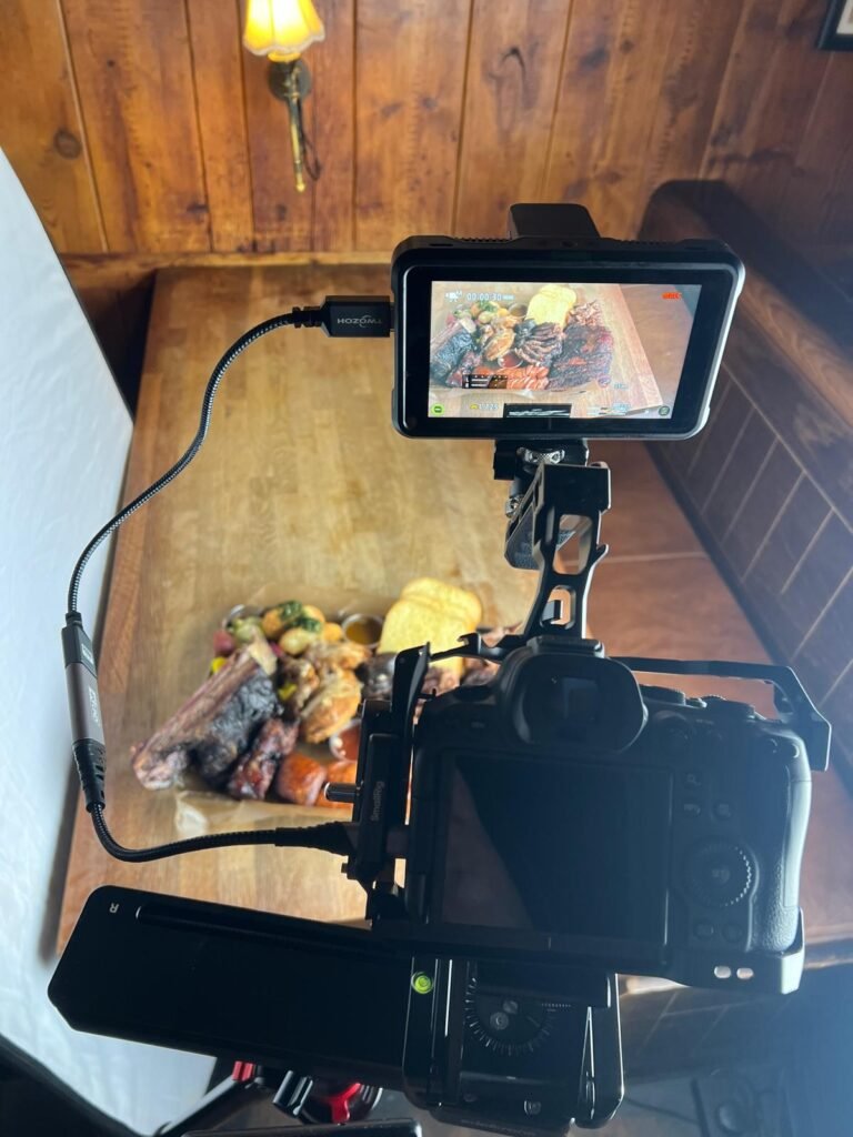Filming a barbecue platter in the restaurant on a tripod with the monitor rolling