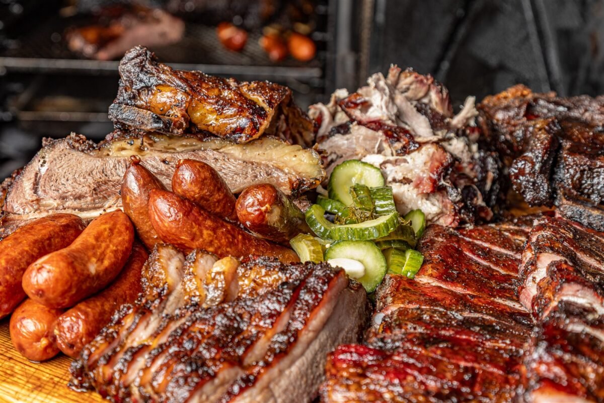 Barbecue sharing board with smoked sausage, ribs, pulled pork and pickles