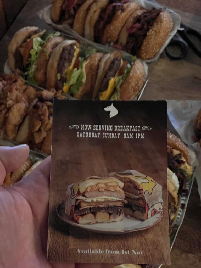 Printed restaurant table card held in hand, carrying the photograph it announces